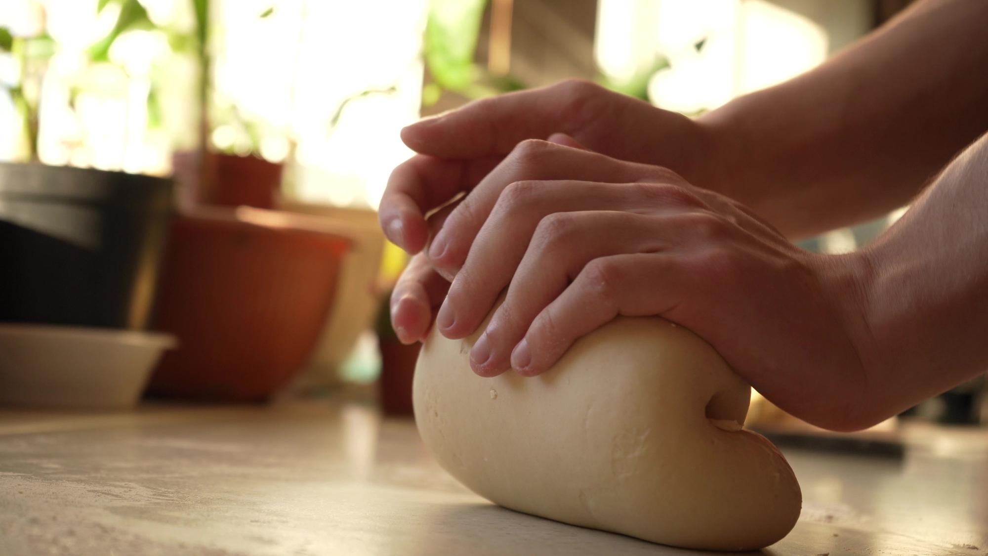 Mãos do aluno preparando massa